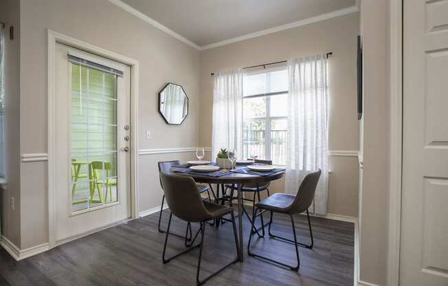 Pet-Friendly Apartments in Tyler, TX - Dining Room with Large WIndow, Plank Wood Flooring and Access to Patio.
