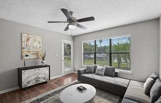 Model Living Room with Wood-Style Flooring and Patio Accessibility at Fountains Lee Vista Apartments in Orlando, FL.