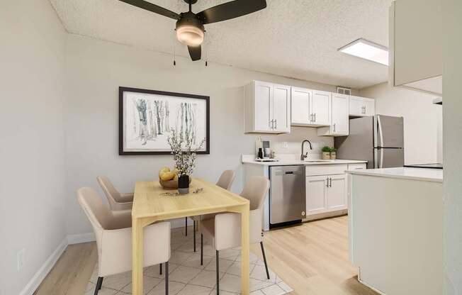 Aurora, CO Apartments – Aurora Meadows – A dining room with a table and chairs and a painting on the wall.