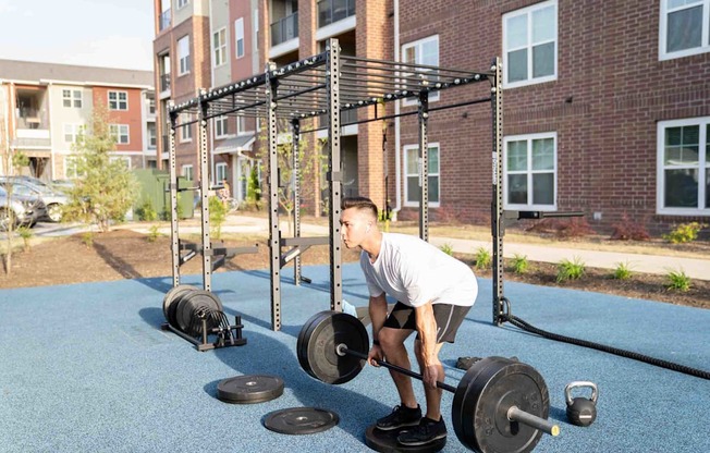 A man is lifting weights in a park.