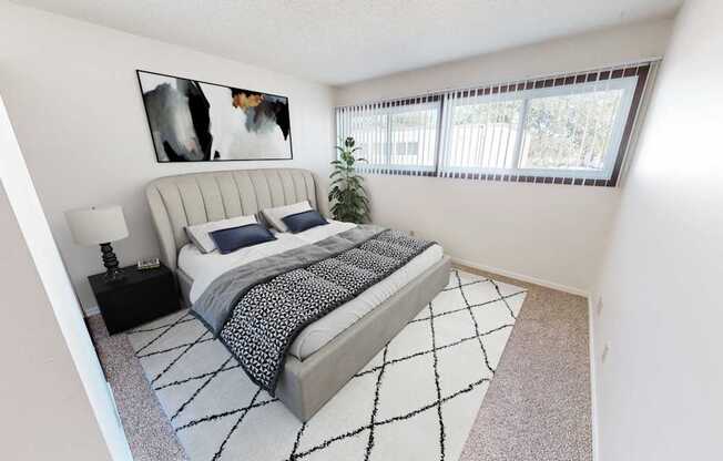 a bedroom with a bed and a large window