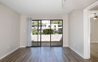 an empty living room with sliding glass doors to a yard