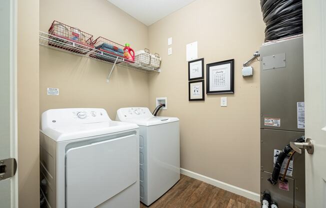 a washer and dryer in a laundry room with a door to a closet