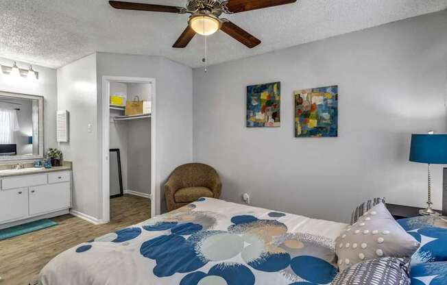 A bedroom with a bed, a chair, and a ceiling fan.at Viva Max, Texas, 78228