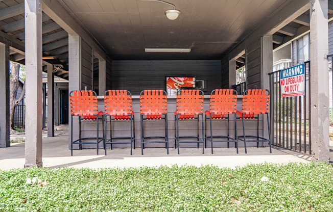 a row of orange chairs in front of a building