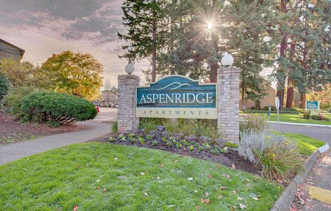 A sign that says Aspenridge Apartments in front of a building.