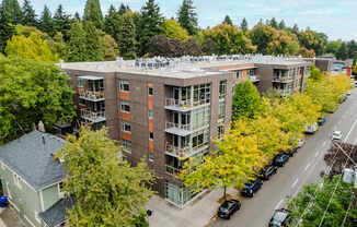 A large apartment building with a parking lot in front.