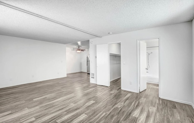 an empty living room with white walls and wood flooring