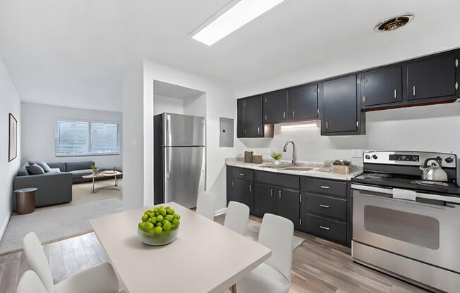 a kitchen and dining room with black cabinets and stainless steel appliances