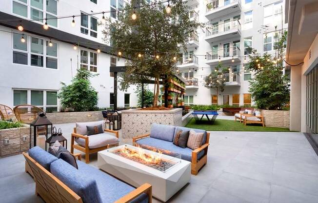 Gather around a firepit under sparkling string lighting in one of two stunning courtyards at Modera San Diego