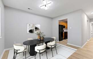 A dining room with a black table and white chairs.