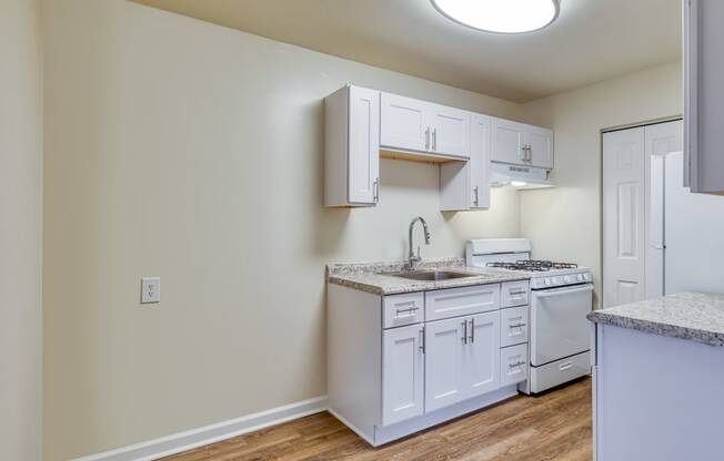 an empty kitchen with white cabinets and a white stove and refrigerator at Gates of West Bay in Norfolk, Virginia