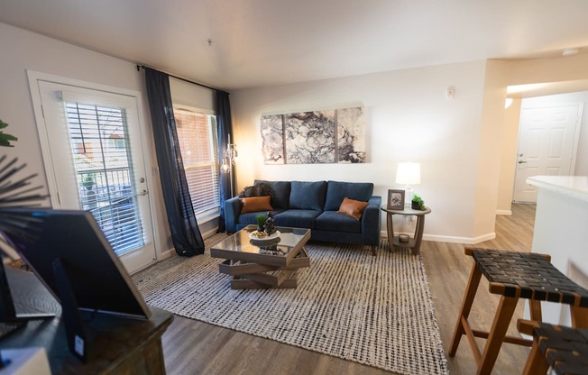 A living room with a blue couch and a coffee table.