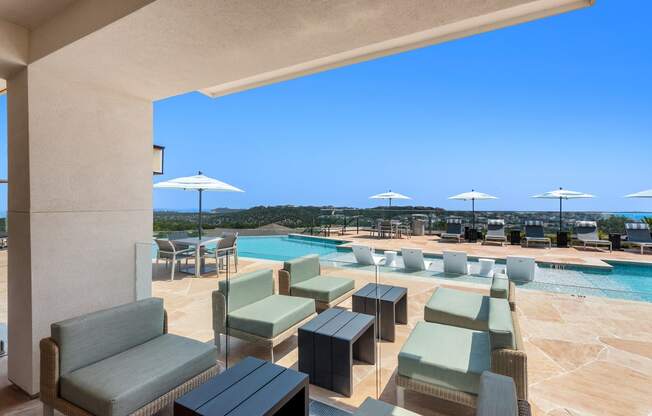 a view of a swimming pool with tables and chairs and umbrellas