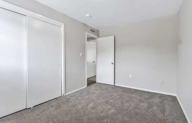 an empty bedroom with white walls and white doors