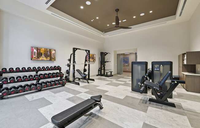 a spacious fitness room with weights and cardio equipment