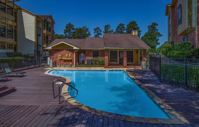 a house with a pool in front of a brick building