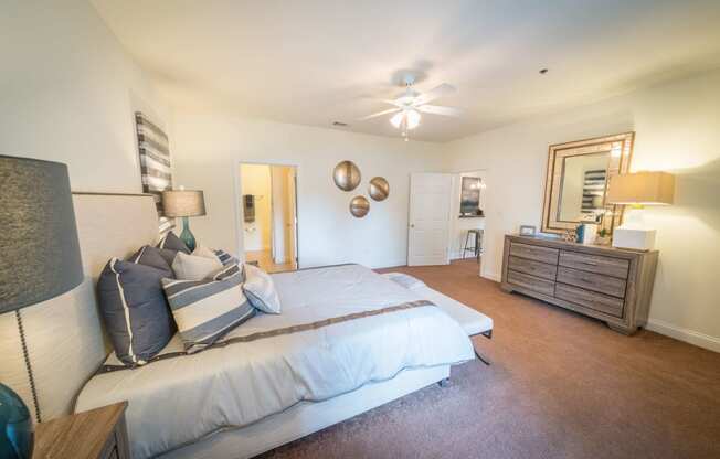 a bedroom with a bed and a dresser and a ceiling fan