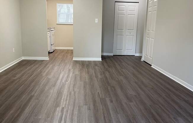 an empty living room with wooden floors and a ceiling fan