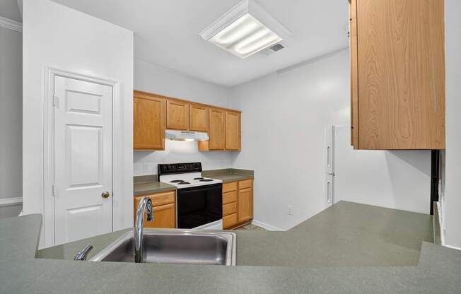 A classic 2 style kitchen with stove, sink and wooden cabinets