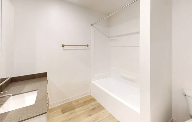 A white bathroom with a sink, toilet and bathtub.