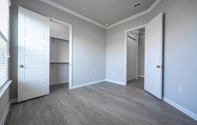 Bedroom with hard wood flooring, gray walls, and white crown molding