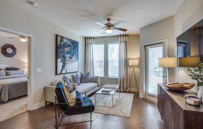 A living room with a couch, chair, and a painting on the wall.