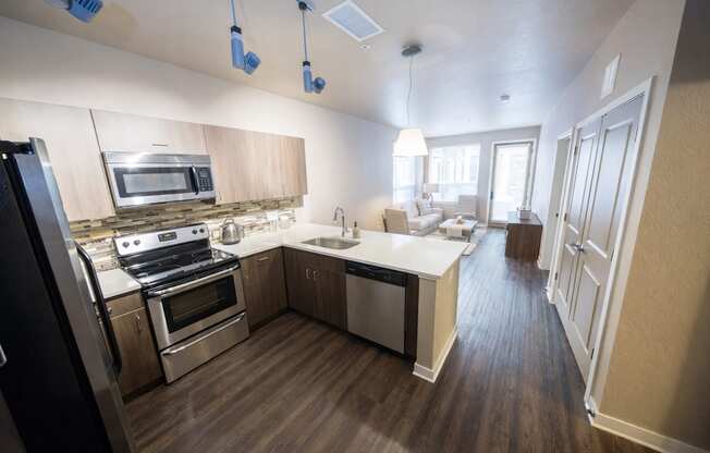 A modern kitchen with stainless steel appliances and wooden floors.