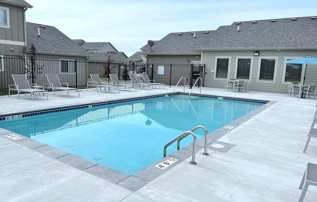 Sparkling blue pool surrounded by lounge chairs.