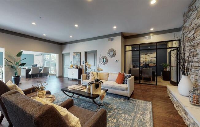 A modern living room with a stone wall and a large window.