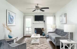 A living room with a grey couch, a white coffee table, and a fireplace.