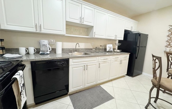 a kitchen with black appliances and white cabinets