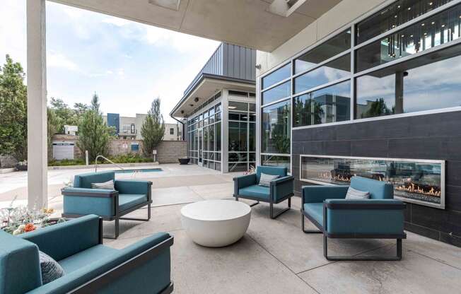 a terrace with blue chairs and a coffee table