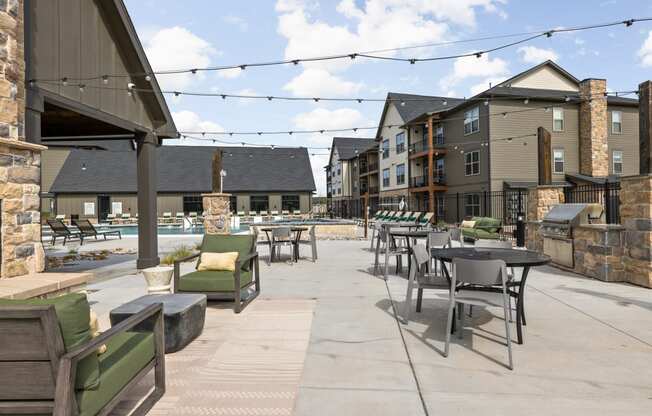 an outdoor patio with tables and chairs at the residences at town center apartments