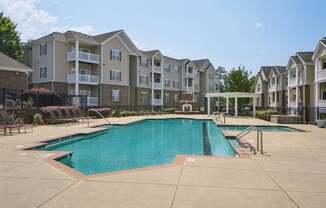 A large swimming pool in front of apartment buildings.