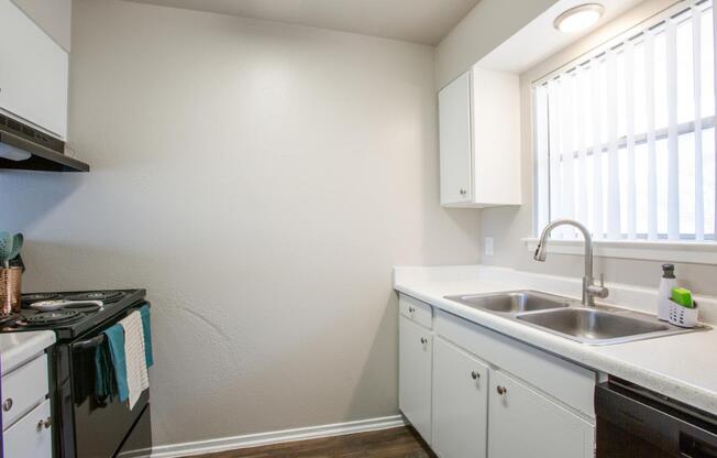 A kitchen with white cabinets and a black stove top oven.