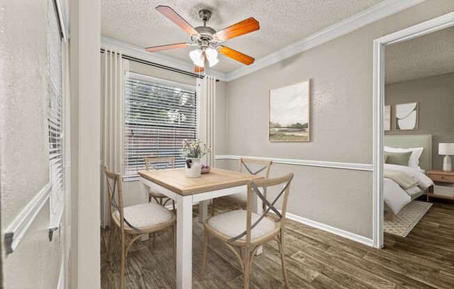 a dining room with a table and chairs and a ceiling fan