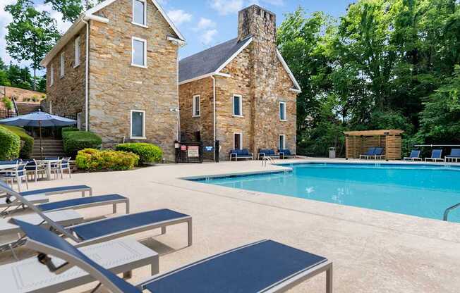 A pool with sun loungers and a building behind it. at Mill House at East Cobb, Georgia