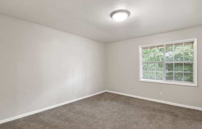 an empty room with carpet and a window