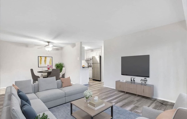 A living room with a grey couch, a coffee table, and a flat screen TV.