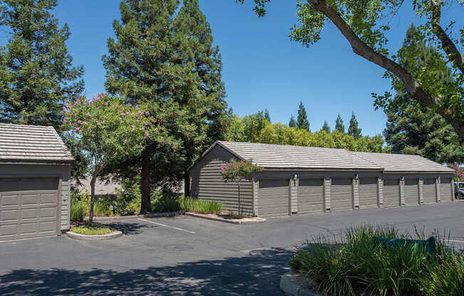 A parking lot with garages and trees at Sunset Summit, Rocklin, CA, 95765