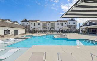 our apartments have a large swimming pool with chairs and umbrellas
