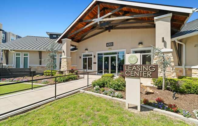 A leasing center with a sign in front of it.