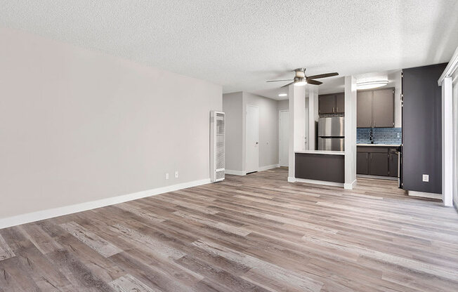 Hardwood floored living room with view of dining area and kitchen.