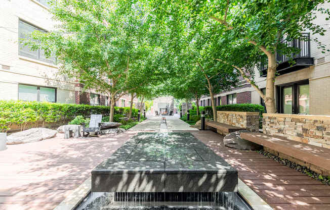 Photo of a peaceful courtyard with water features and lush greenery.