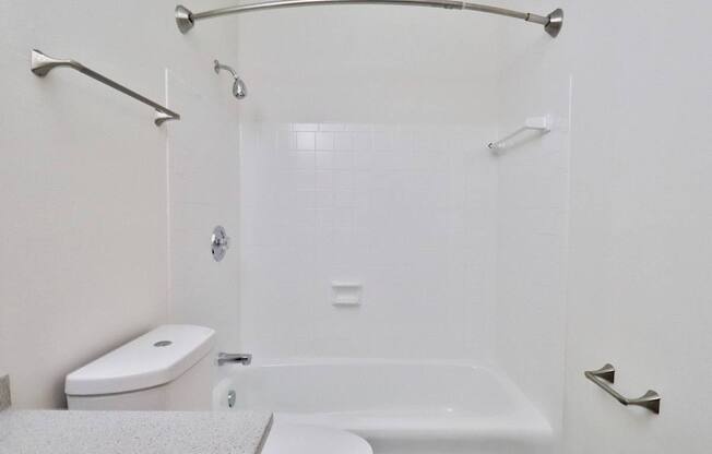 a white bathroom with a shower and a toilet