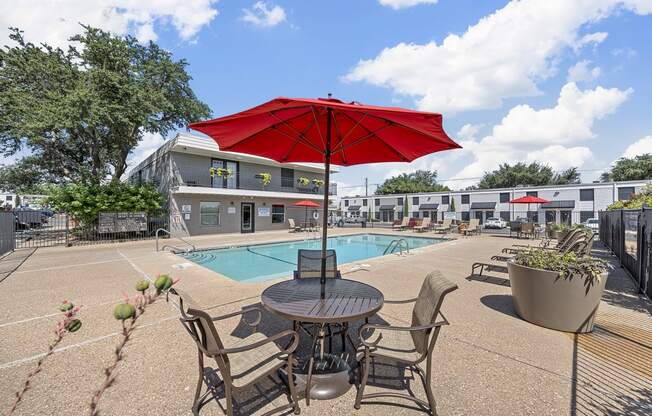 our apartments have a pool and a patio with chairs and an umbrella at Brookside Apartments, Hewitt, Texas