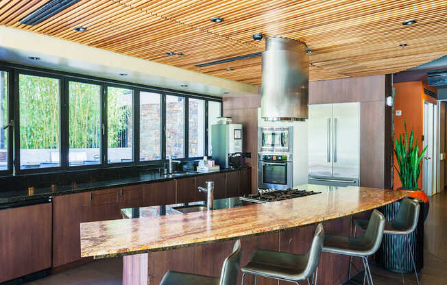 A modern kitchen with a wooden ceiling and island.
