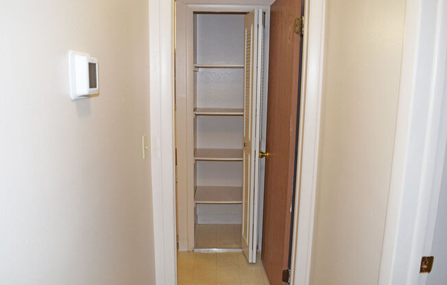 a room with a closet and a door with shelves at Seville Apartments in Kalamazoo, MI 49009