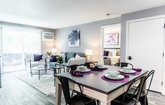 a living room with a dining room table and chairs and a couch and chair in the background